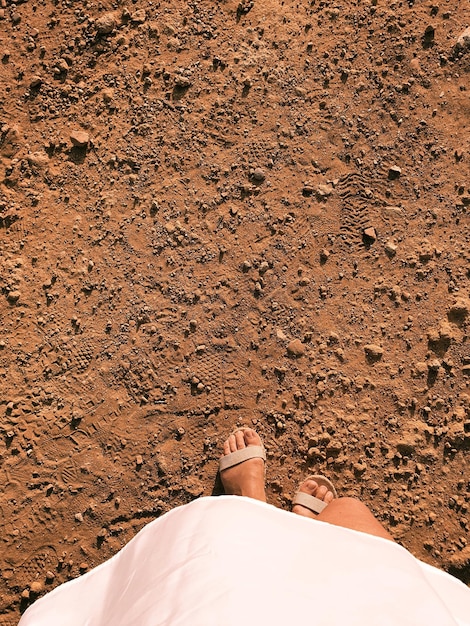 Foto sezione bassa di una donna in piedi sulla sabbia