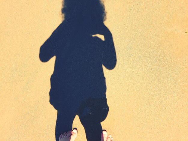 Low section of woman standing on shadow