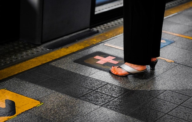 Foto sezione bassa di una donna in piedi sul pavimento piastrellato