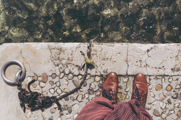 Foto sezione bassa di una donna in piedi sul pavimento piastrellato