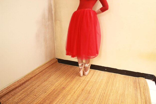 Low section of woman standing on wooden floor