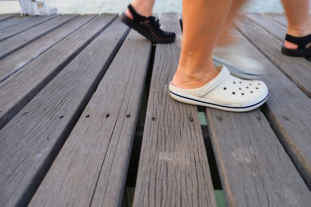 Low section of woman standing on wooden footpath