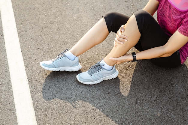 Photo low section of woman suffering from leg pain on road