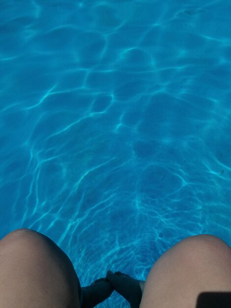 Low section of woman swimming in pool