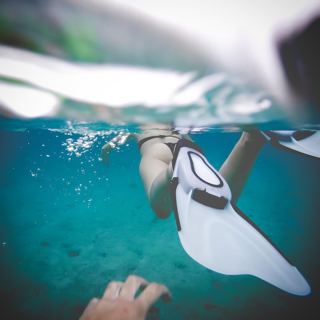 Low section of woman swimming in sea