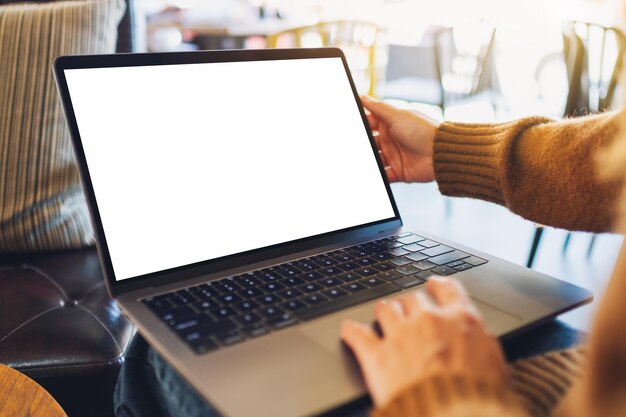 Low section of woman using laptop in cafe