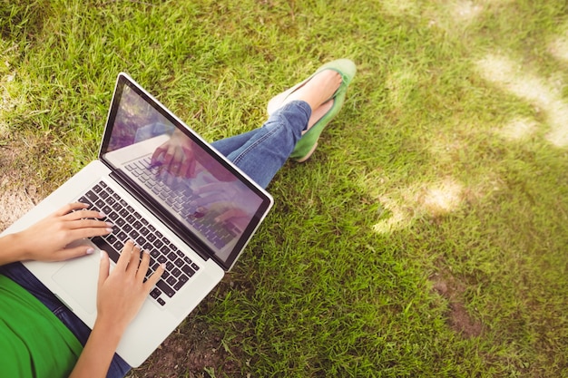 Low section of woman using laptop in park