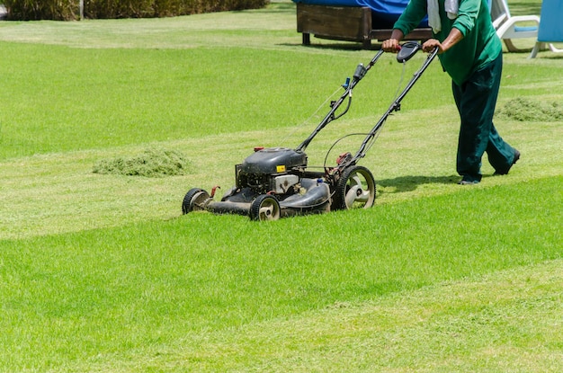 Sezione inferiore di una donna che usa macchinari sull'erba