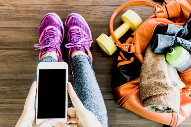 Photo low section of woman using mobile phone while sitting on hardwood floor