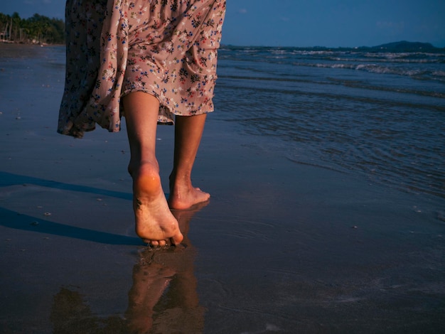 Low section of woman walking at beach