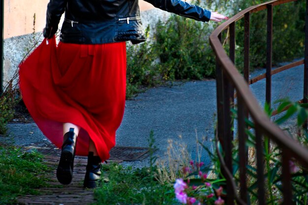 Low section of woman walking by railing