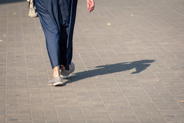 Photo low section of woman walking on footpath