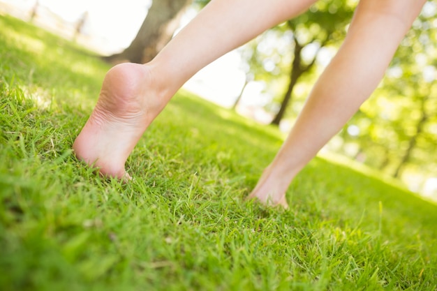 Low section of woman walking on grass