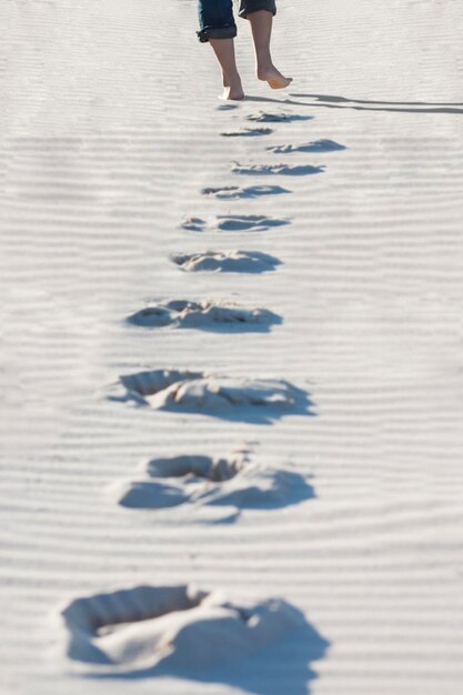 Photo low section of woman walking on sand at beach