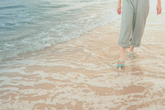 Low section of woman walking in sea