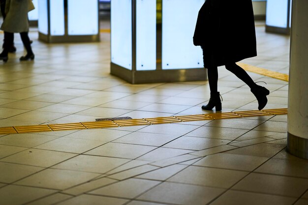 Foto sezione bassa di una donna che cammina alla stazione della metropolitana