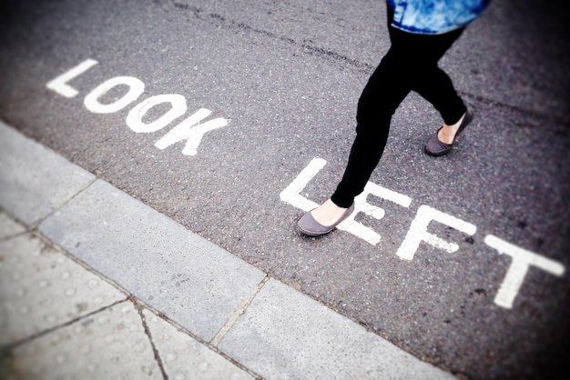 Low section of woman walking on text at street