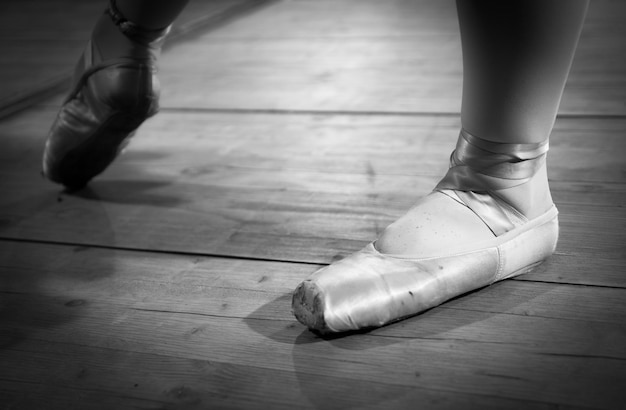 Foto sezione bassa di una donna che indossa una ballerina di balletto sul pavimento di legno