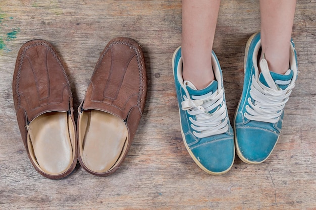 Photo low section of woman wearing canvas shoes on wooden floor