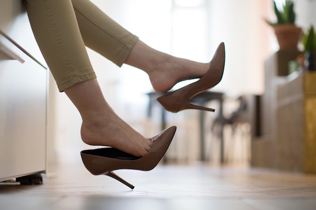 low section of woman wearing high heels at home