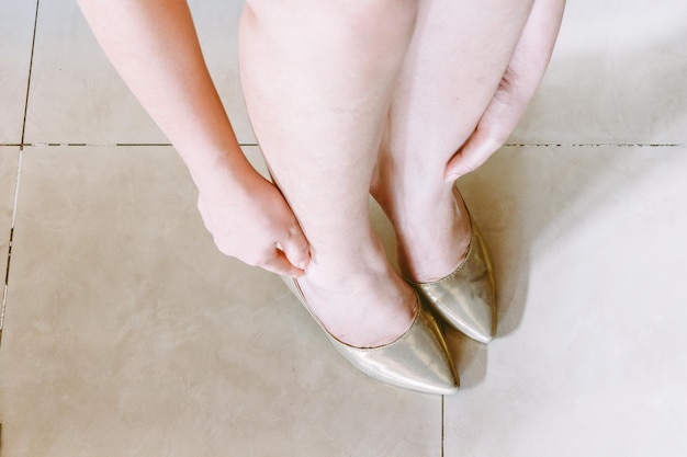 Photo low section of woman wearing shoes on tiled floor