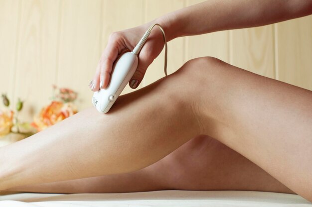 Photo low section of woman with appliance on bed