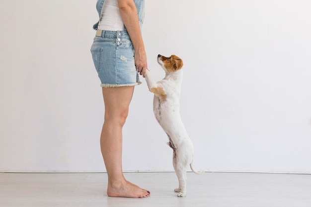 Photo low section of woman with dog standing against wall