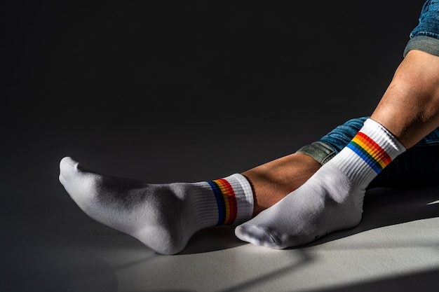 Photo low section of woman with rainbow colored socks on floor in darkroom