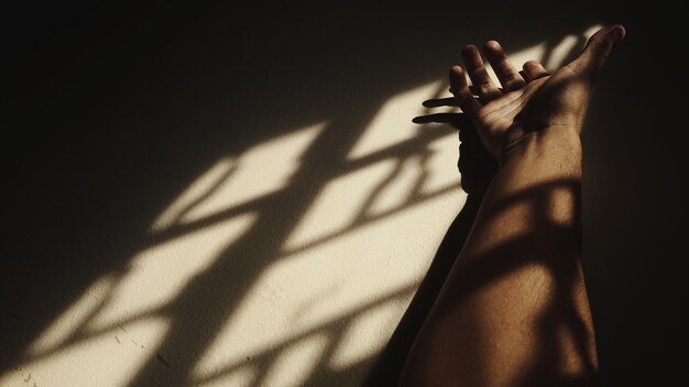 Low section of woman with shadow on wall