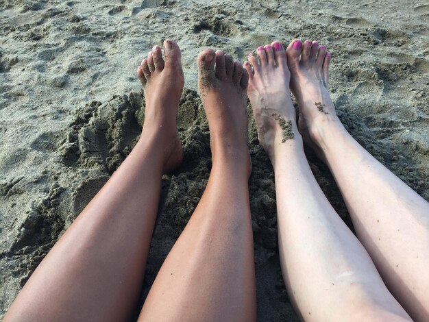 Photo low section of women relaxing on beach