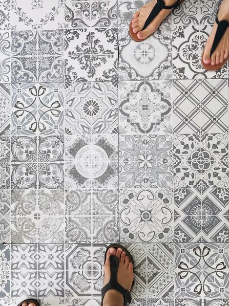 Low section of women standing on patterned floor