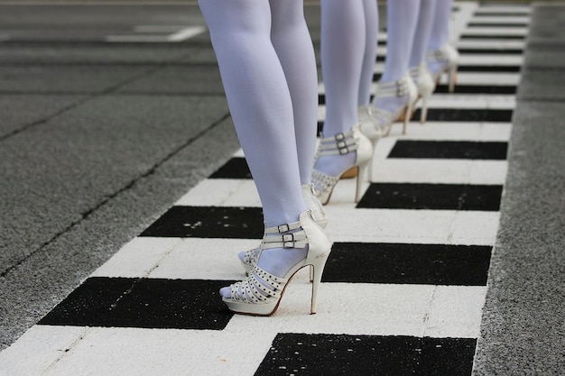 Photo low section of women standing on road marking