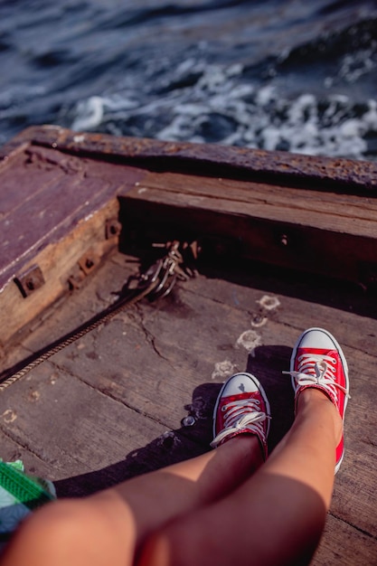 Photo low section of young woman on boat in sea