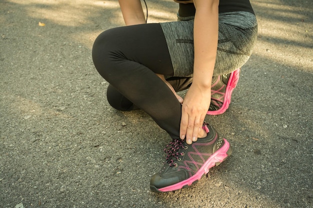 Low section of young woman exercising on road