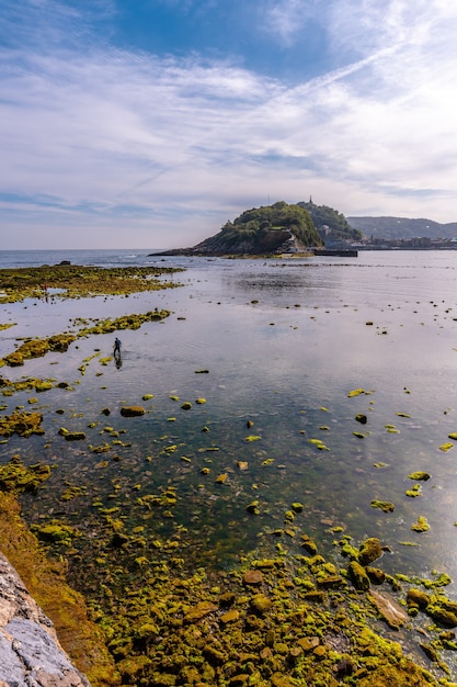 Low tide on the beach of Ondarreta in San Sebastian and the island behind