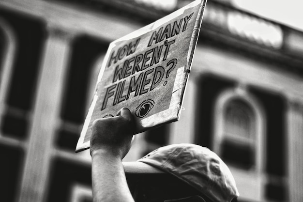 Foto angolo di visione basso della persona che tiene il cartello di protesta