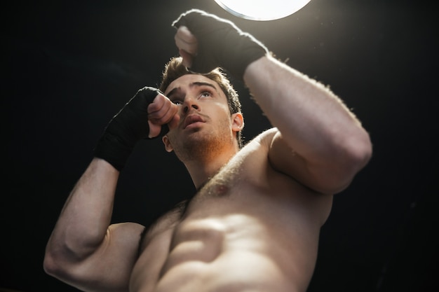 Low view of sportsman wearing gloves and boxing