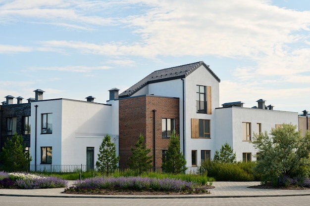 Low white and brown houses standing in row in rural environment