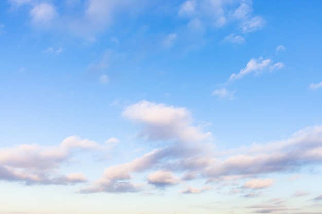 Low white gray and pink clouds in blue sky