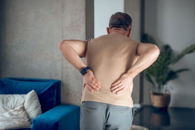 Photo lower back pain. a man having pain in his lower back