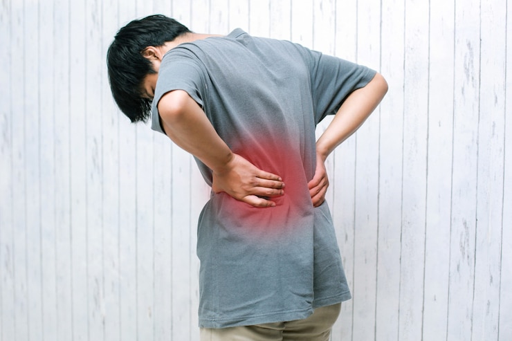 Photo 若い男が痛みで背中を保持している腰痛