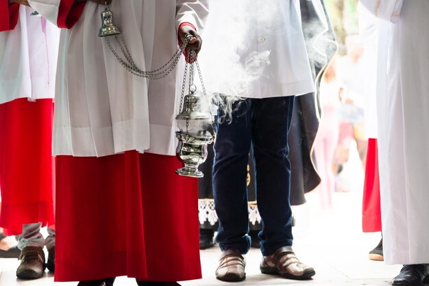 Foto parte inferiore dei membri della chiesa cattolica con l'incenso nella chiesa del cimitero di campo santo