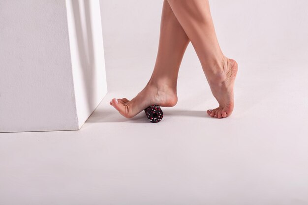 The lower part of the girl's legs on a white background Roll for stretching