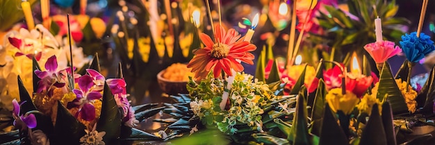 La gente del festival loy krathong compra fiori e candele da accendere e galleggia sull'acqua per celebrare il loy