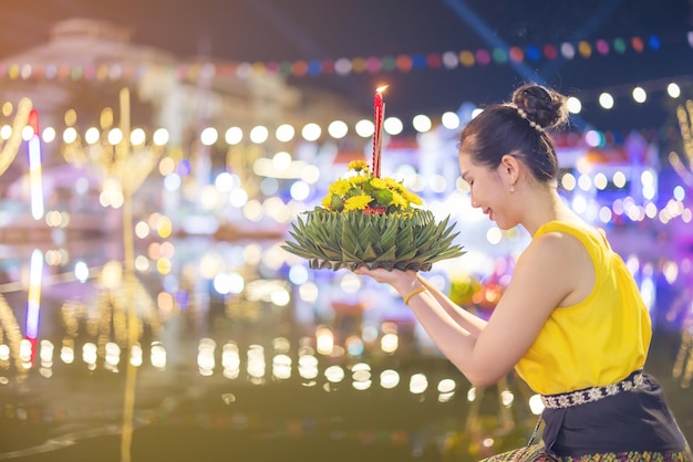 写真 ロイクラトンの伝統的な祭り タイの美しい女性が満月の夜に水の女神のためにタイのロイクラトンのお祝いでクラトンの装飾的な形のバナナの葉を保持しています