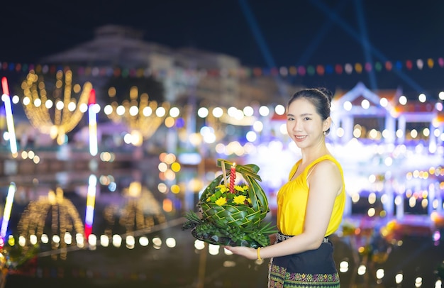 Loy Krathong Traditional Festival Een mooie Thaise vrouw houdt een Krathong-bananenblad in de vorm van een bananenblad in Loy Krathong-vieringen in Thailand voor de godin van het water op een volle maannacht