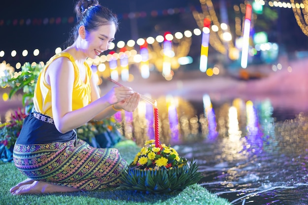 Loy Krathong Traditional Festival Een mooie Thaise vrouw houdt een Krathong-bananenblad in de vorm van een bananenblad in Loy Krathong-vieringen in Thailand voor de godin van het water op een volle maannacht