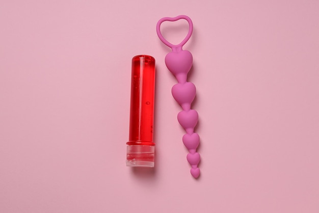 Lubricant with anal balls on a pink background