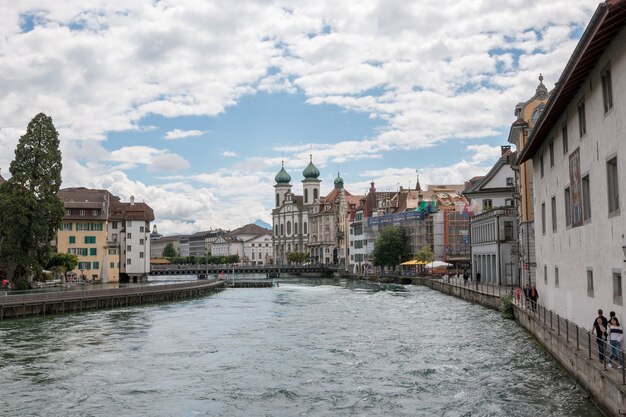 Lucerne, Switzerland - July 3, 2017: Panoramic view of city center of Lucerne and river Reuss. Dramatic sky and sunny summer landscape