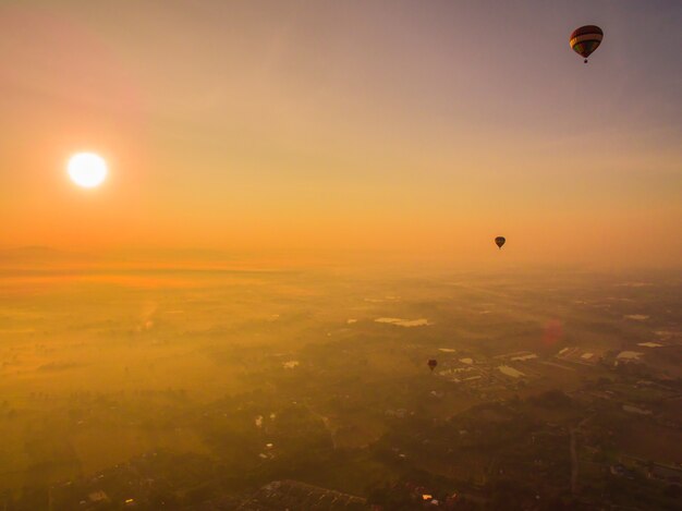 Luchtballon over de stad in de ochtendzonsopgang